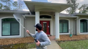 "man pressure cleaning the front of a beige house in Naples FL"