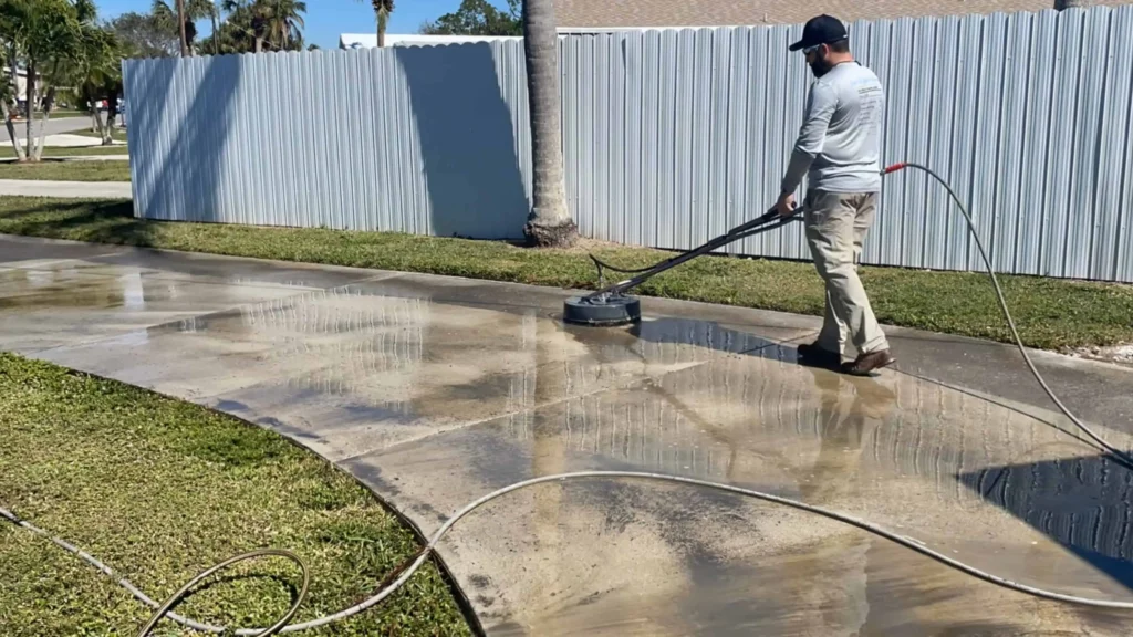 "A professional using a surface cleaner for driveway pressure cleaning on a concrete driveway"
